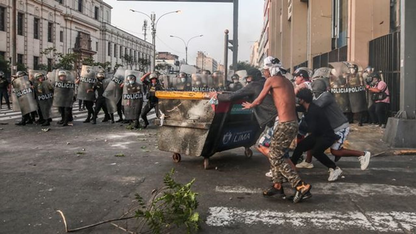 Demonstranten stoßen mit der Polizei auf einer Straße in Lima zusammen.