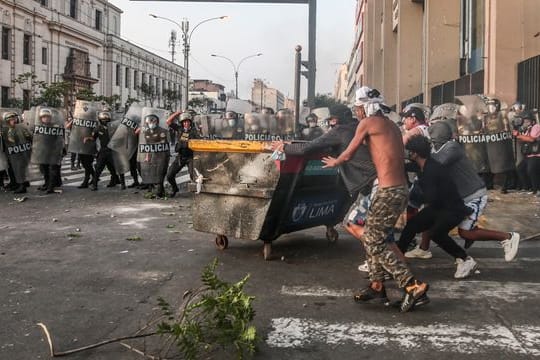 Demonstranten stoßen mit der Polizei auf einer Straße in Lima zusammen.