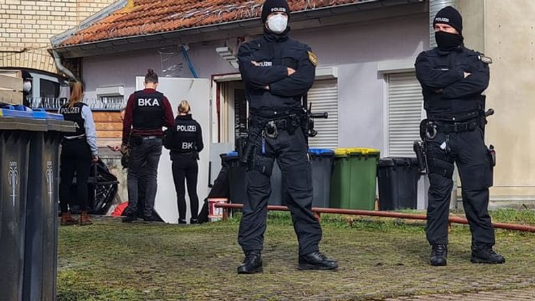 Polizisten vor dem Hintereingang eines Gebäudes in Eisenach, das sie durchsuchen.