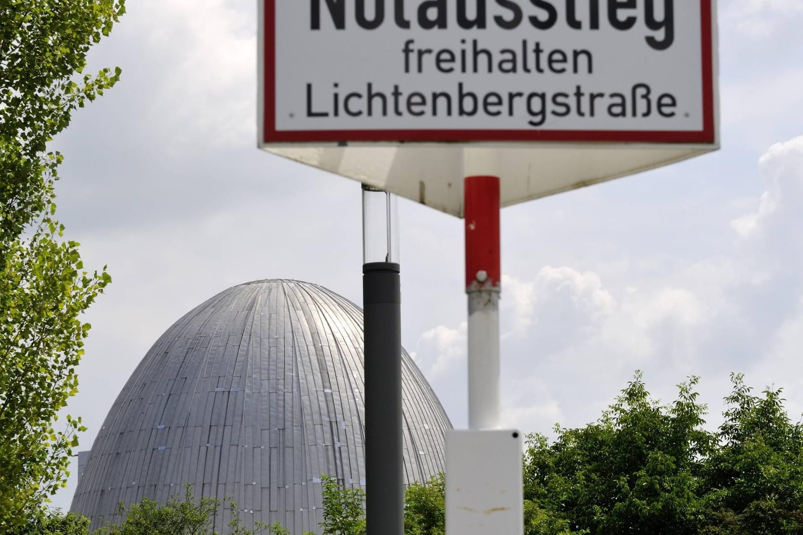 Schild "Notausstieg freihalten" vor dem Forschungsreaktor FRM II in Garching bei München (Archivbild). Die Grünen im Bayerischen Landtag lehnen einen Transport abgebrannter Brennelemente aus dem Forschungsreaktor in Garching ins nordrhein-westfälische Zwischenlager Ahaus ab.