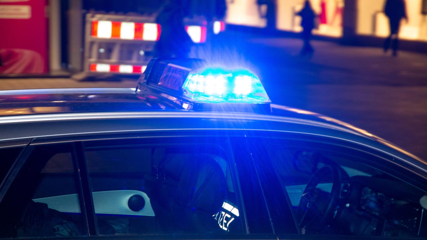 Einsatzfahrzeug der Polizei mit Blaulicht bei Dunkelheit (Symbolbild): Die Berliner Polizei durchsuchte im Rahmen einer Razzia mehrere Wohnungen.