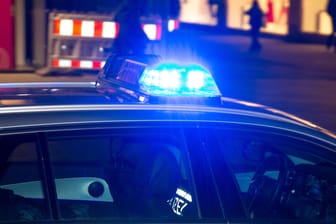 Einsatzfahrzeug der Polizei mit Blaulicht bei Dunkelheit (Symbolbild): Die Berliner Polizei durchsuchte im Rahmen einer Razzia mehrere Wohnungen.