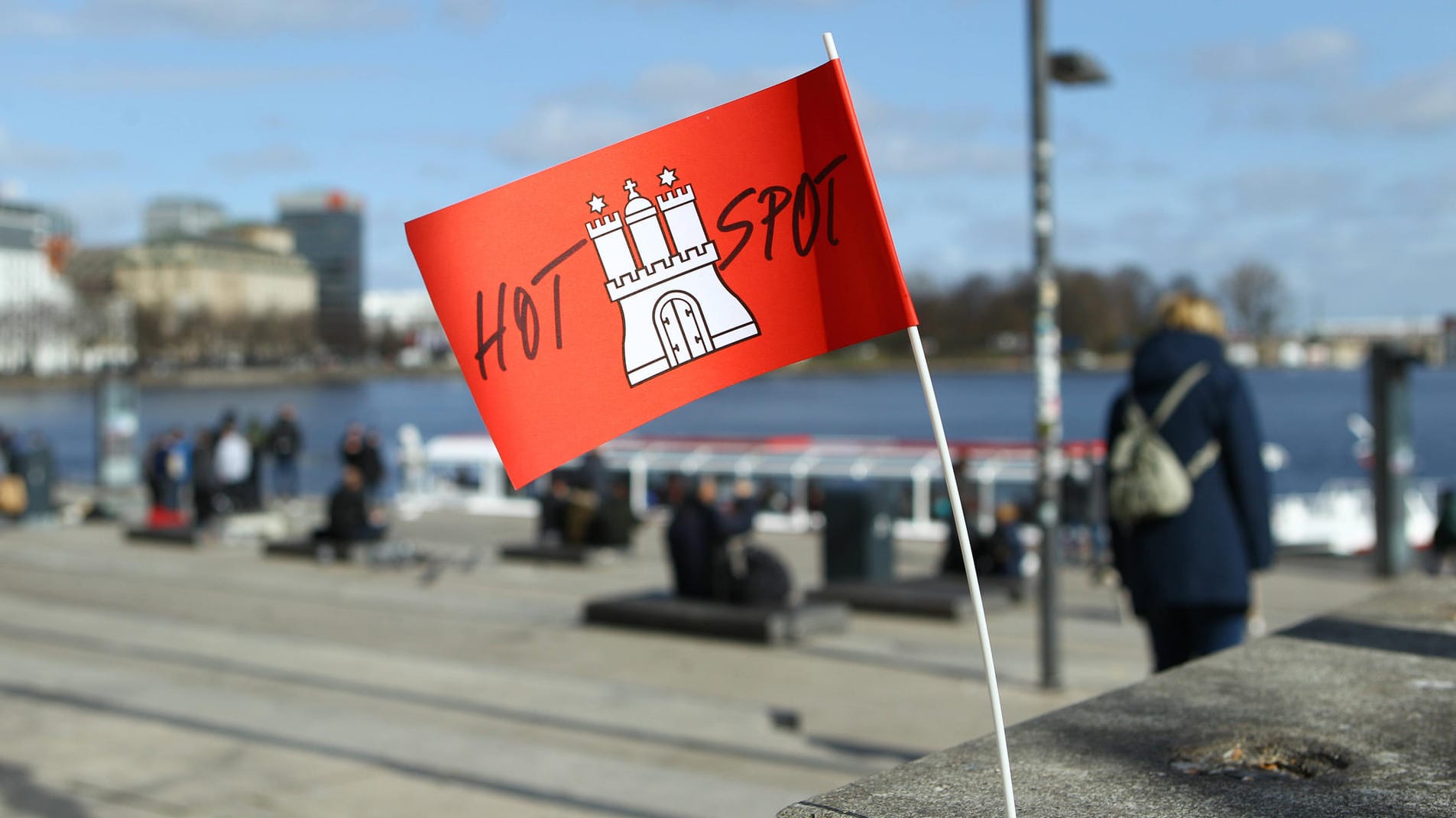 Eine Papierfahne mit dem Hamburg-Wappen und der Aufschrift Hotspot steckt in einem Betonpfeiler am Jungfernstieg. Im Hintergrund die Alster (Symbolbild). Die Hamburger AfD geht wie angekündigt gerichtlich gegen die Corona-Hotspot-Regelung in der Hansestadt vor. Eine Papierfahne mit dem Hamburg-Wappen und der Aufschrift Hotspot steckt in einem Betonpfeiler am Jungfernstieg. Im Hintergrund die Alster (Symbolbild). Die Hamburger AfD geht wie angekündigt gerichtlich gegen die Corona-Hotspot-Regelung in der Hansestadt vor.