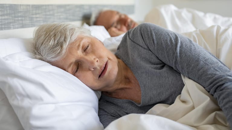 Eine ältere Frau beim Schlafen. Vermehrtes Schlafen am Tag könnte auf eine Demenzerkrankung hindeuten.
