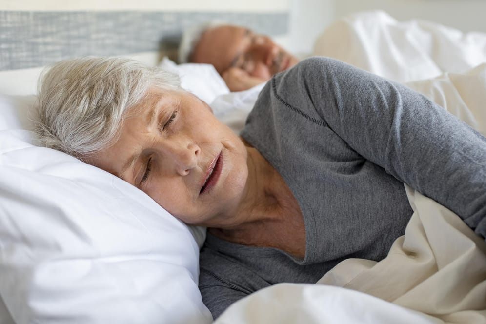 Eine ältere Frau beim Schlafen. Vermehrtes Schlafen am Tag könnte auf eine Demenzerkrankung hindeuten.