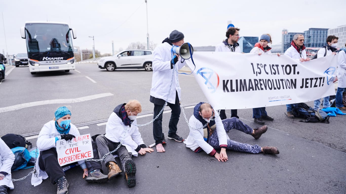 Demonstranten haben Hände und Füße auf die Straße geklebt: Wissenschaftler unterschiedlicher Bereiche haben die Kronprinzenbrücke blockiert.