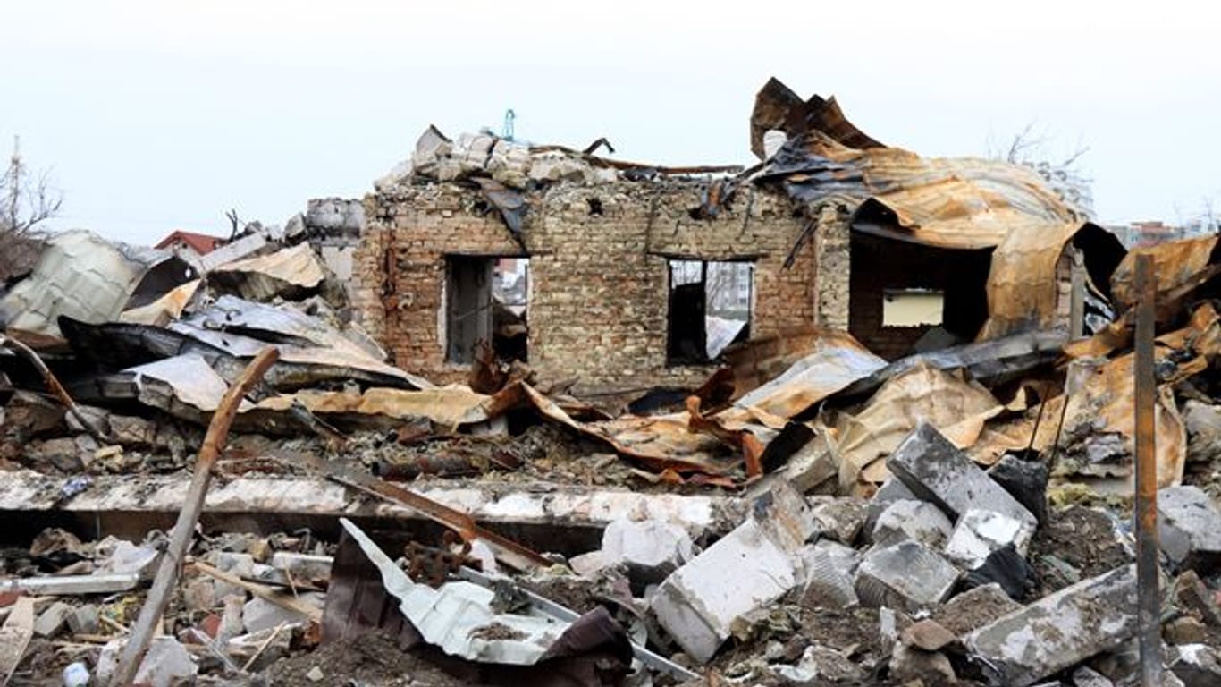 Trümmer eines zerstörten Gebäudes liegen nach dem Abzug der russischen Truppen auf einer Straße in Butscha.