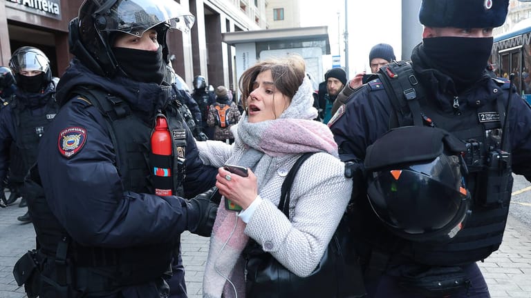 Polizisten in Moskau nehmen eine Frau fest, die gegen den Krieg demonstriert hat.
