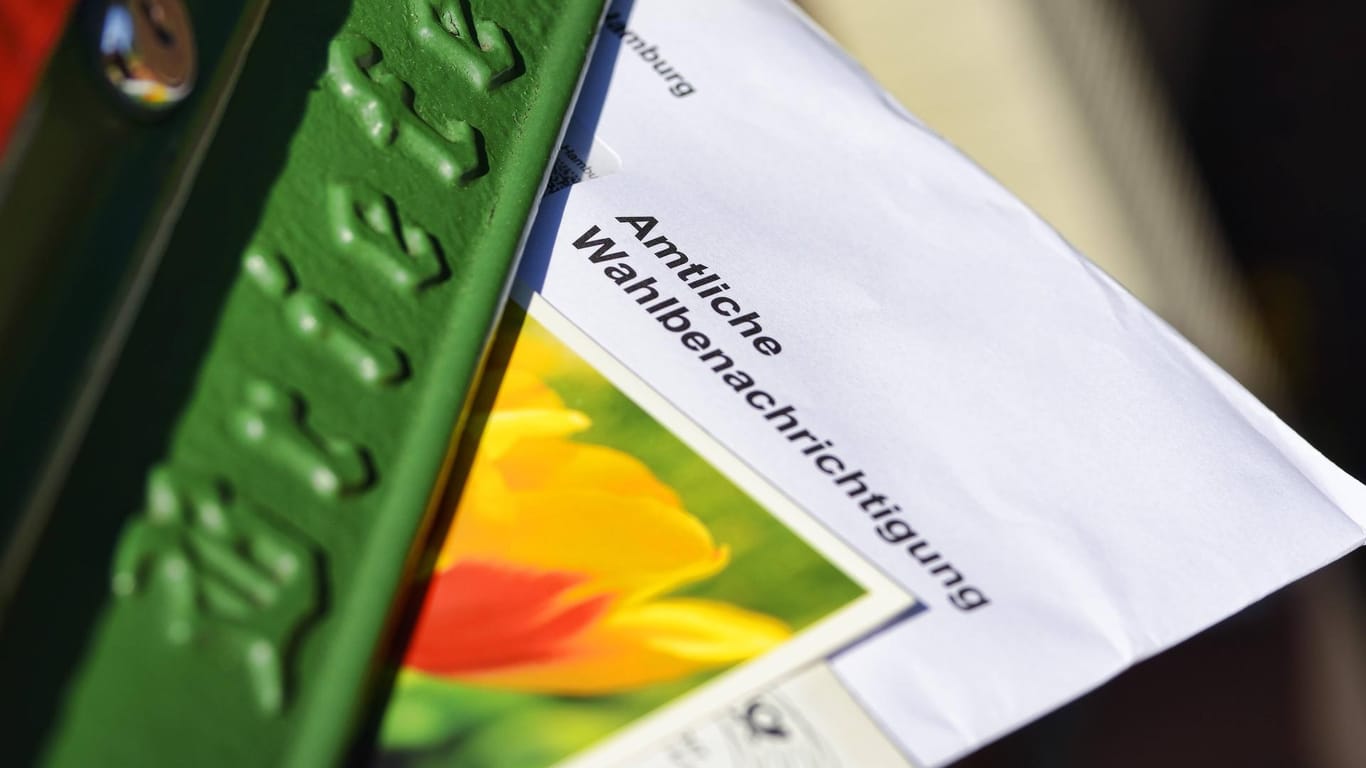 Ein Briefumschlag mit der Aufschrift "Wahlbenachrichtigung" steckt in einem Briefschlitz (Symbolbild): Am 15. Mai findet die Landtagswahl 2022 in NRW statt.
