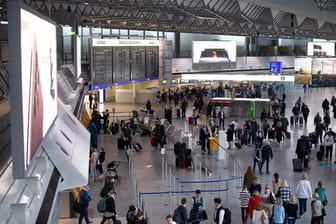Passagiere stehen am Frankfurter Flughafen im Terminal 1