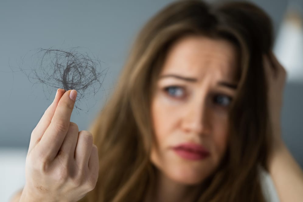 Junge Frau mit Haarausfall: Stresshormone können Entzündungsprozesse verursachen, welche den Haarverlust begünstigen.
