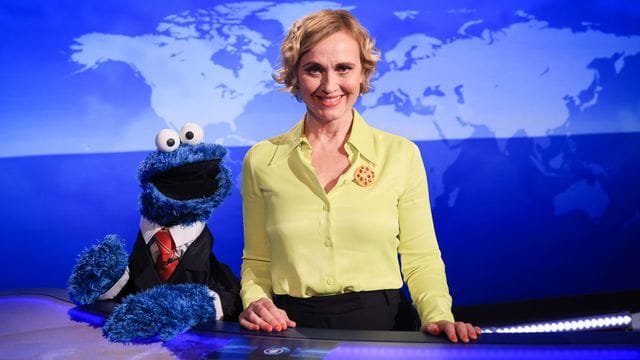 Caren Miosga und das Krümelmonster lächeln in die Kamera.