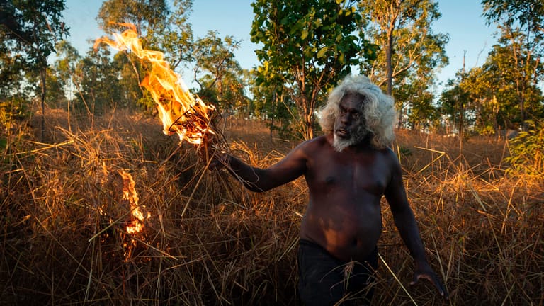 Australien, West Arnhem Land: Ein Aborigine brennt am Ende der Regenzeit Grasland nieder.
