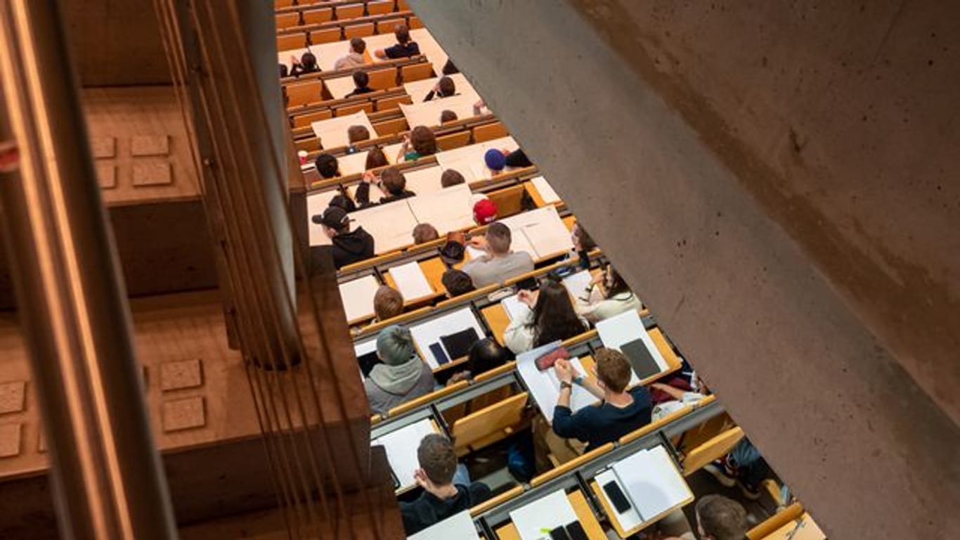 Studierende nehmen in einem Hörsaal an einer Vorlesung teil