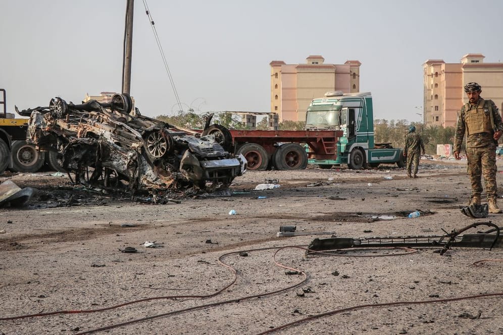 Ein Angehöriger der jemenitischen Sicherheitskräfte inspiziert ein zerstörtes Fahrzeug nach einem Autobombenanschlag.