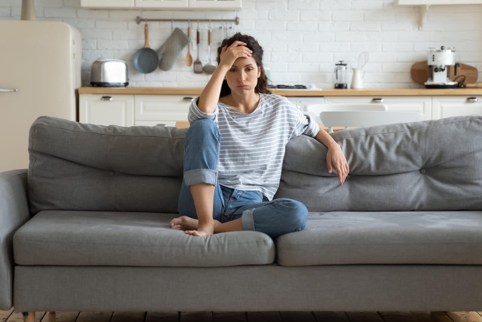 Erschöpfte Frau auf Sofa.