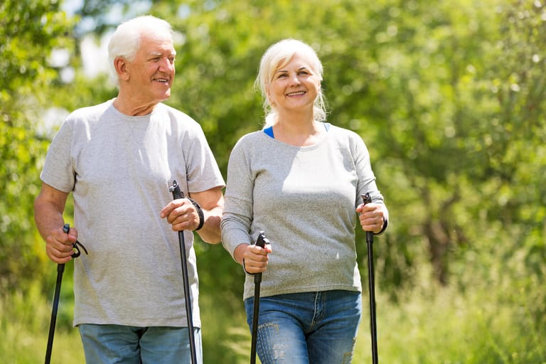 Senioren-Paar beim Walken: Bewegung ist ein wichtiger Faktor zur Vorbeugung von Demenz und verbessert die kognitive Leistung auch noch im hohen Alter.