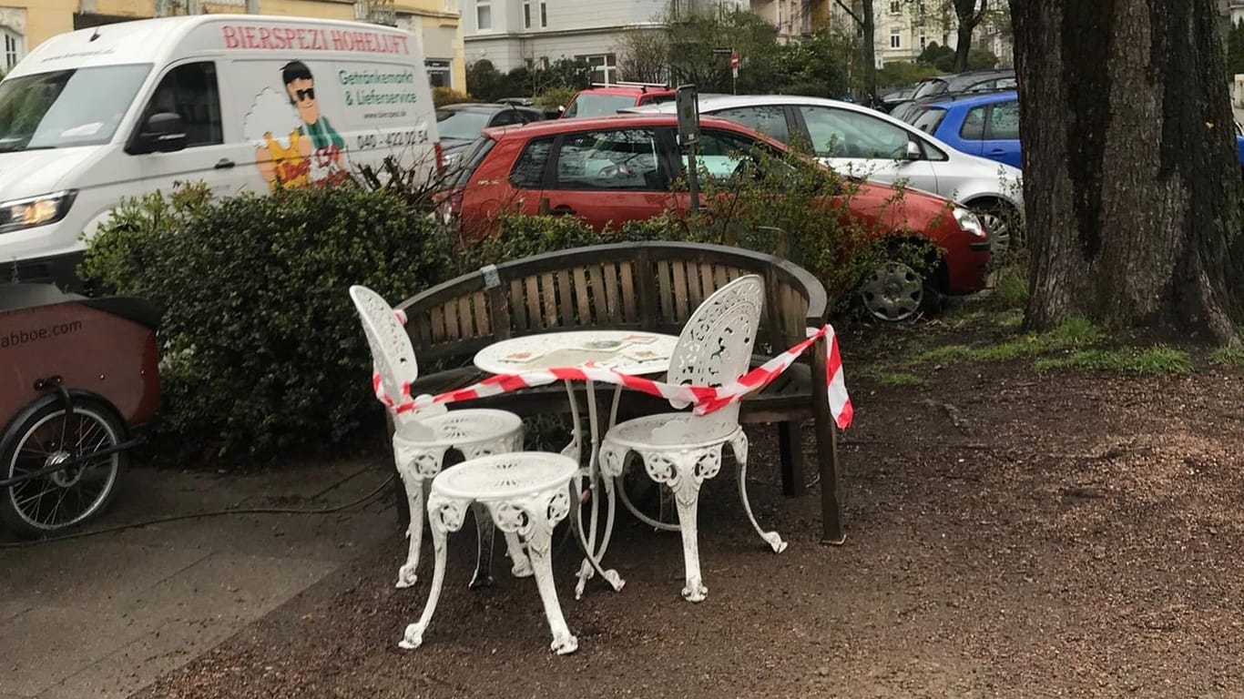 Eine Holzbank, zwei weiße Stühle und ein Tisch: Die Sitzecke in Hamburg-Eppendorf lädt zum Verweilen ein.