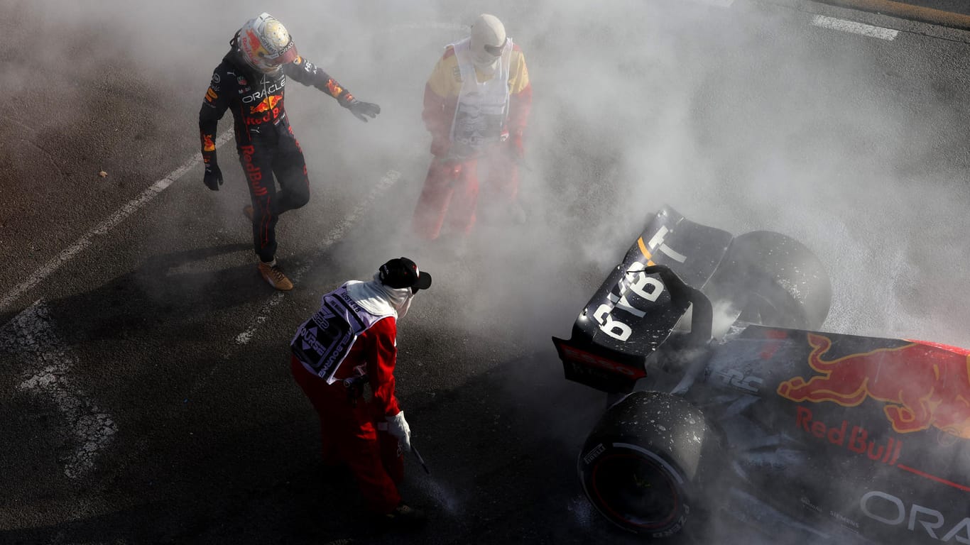 Max Verstappen (li.) vor seinem defekten Auto: Streckenposten löschen die Flammen am Red Bull.
