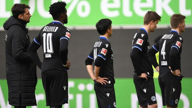 Nach dem 0:4 beim VfL Wolfsburg stehen die Spieler von Arminia Bielefeld mit gesenkten Köpfen auf dem Platz.