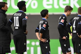Nach dem 0:4 beim VfL Wolfsburg stehen die Spieler von Arminia Bielefeld mit gesenkten Köpfen auf dem Platz.