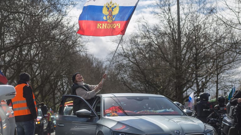 Eine Frau schwenkt aus einem Auto heraus die russische Flagge: 350 Autos ziehen beim prorussischen Autokorso durch die Stadt.