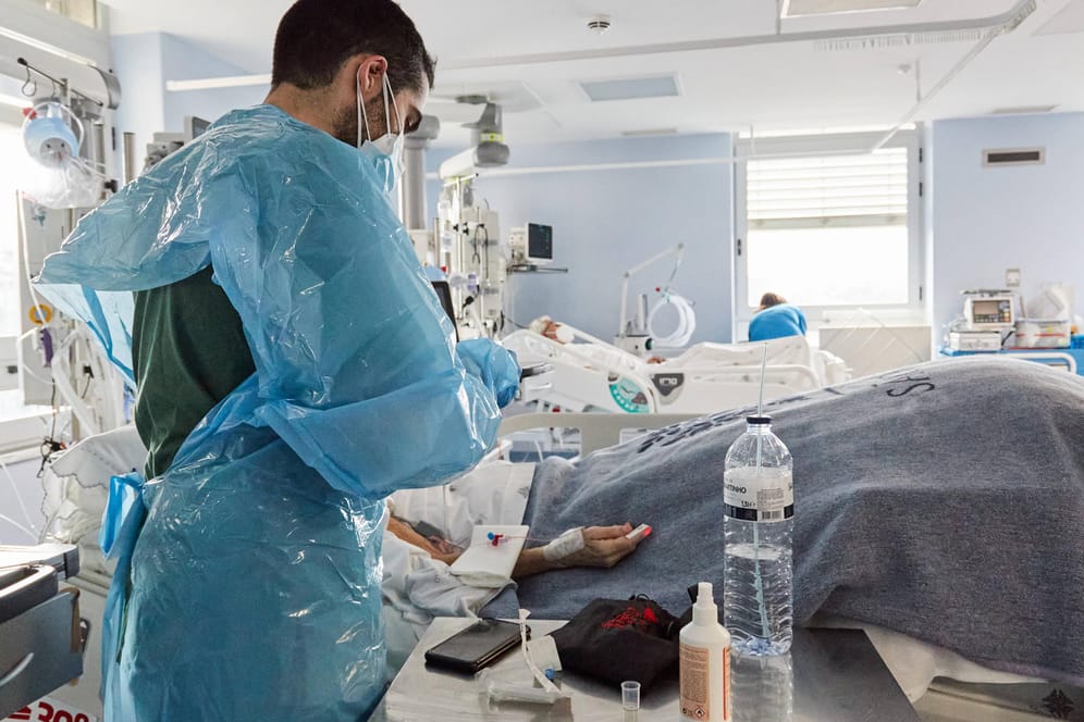 Ein Pfleger kümmert sich um einen Corona-Patienten auf einer Intensivstation (Symbolbild): Noch immer werden in Deutschland täglich Hunderte Tote im Zusammenhang mit Corona gezählt.