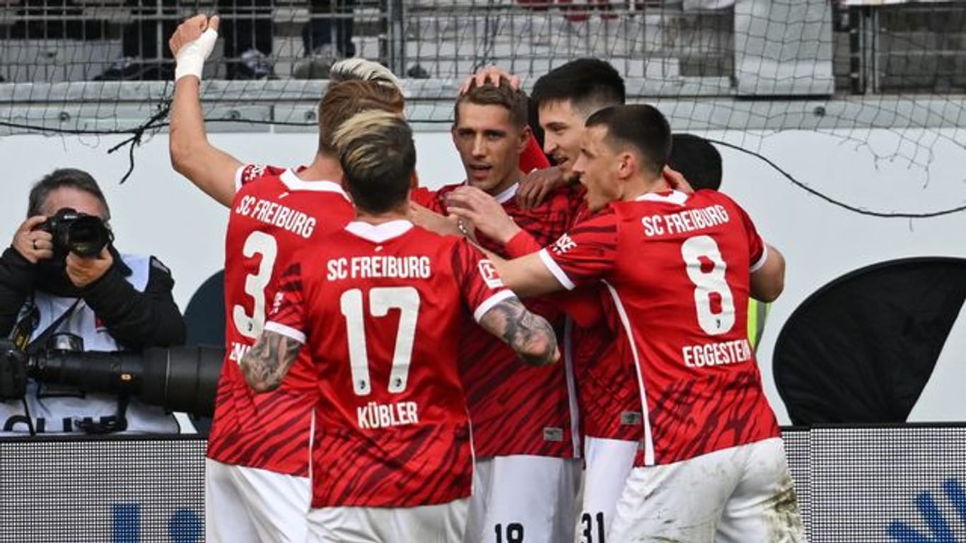 Freiburgs Spieler jubeln nach dem Tor zum 2:1 durch Nils Petersen (M).