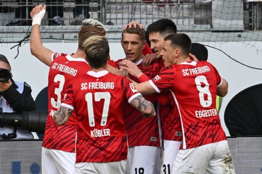 Freiburgs Spieler jubeln nach dem Tor zum 2:1 durch Nils Petersen (M).