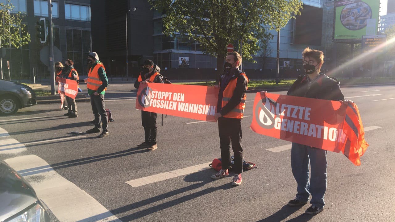 Aktivisten blockieren die Theodor-Heuss-Allee: Sie fordern den Stopp von Investitionen in fossile Brennstoffe.