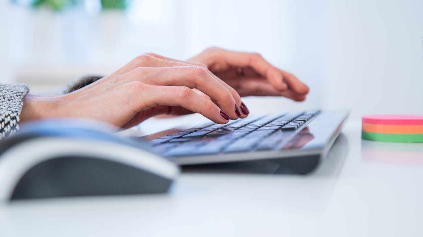 Eine Frau tippt auf einer Tastatur (Symbolbild): Wer seinen Arbeitsvertrag kündigen will, muss eine bestimmte Form wahren.