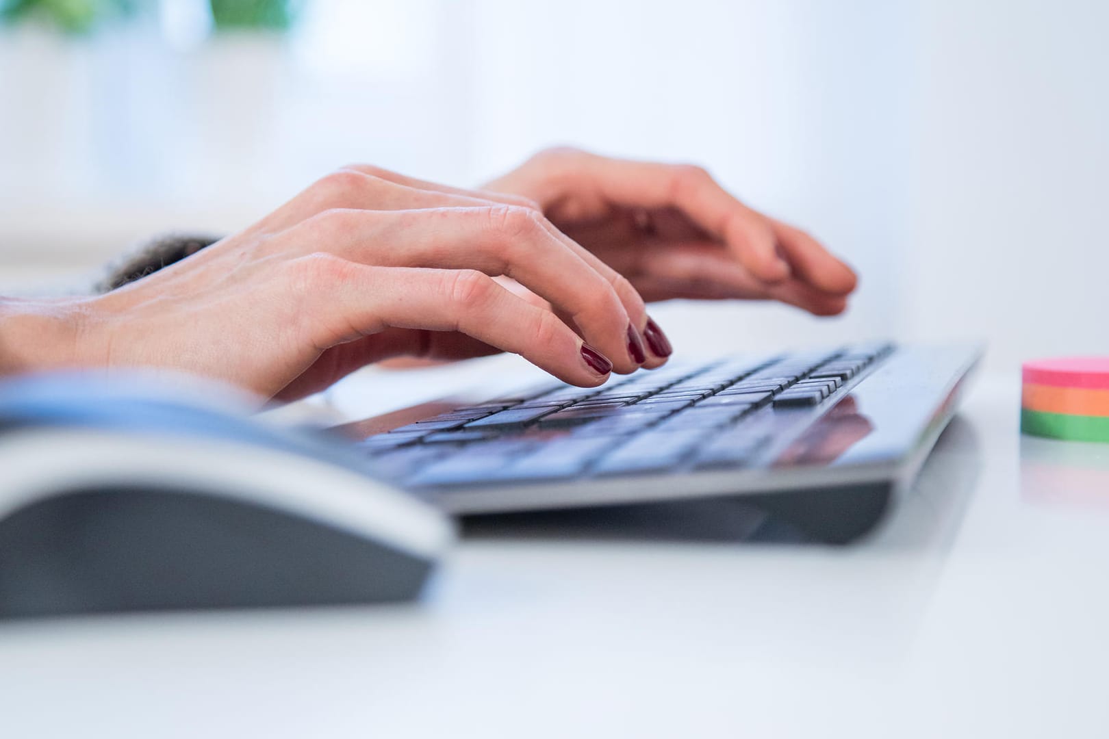 Eine Frau tippt auf einer Tastatur (Symbolbild): Wer seinen Arbeitsvertrag kündigen will, muss eine bestimmte Form wahren.