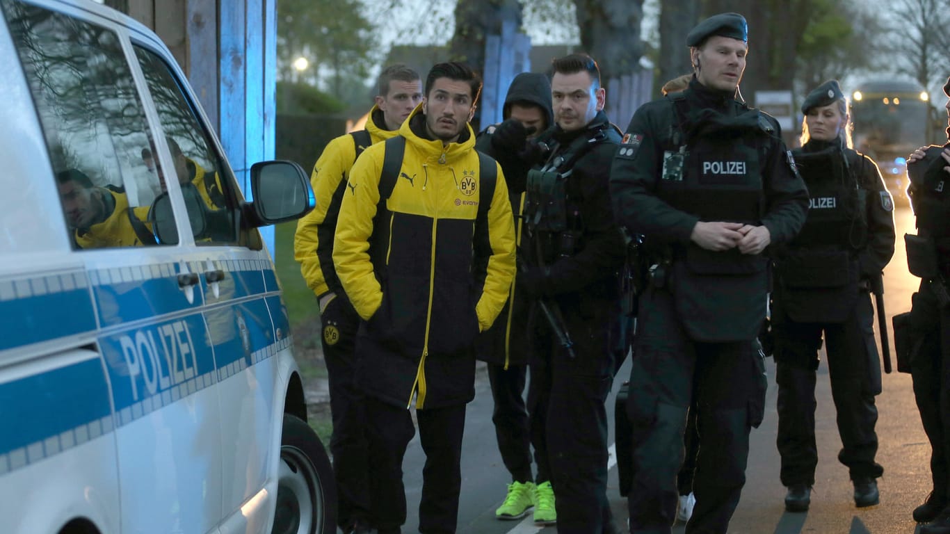 Spieler von Borussia Dortmund, darunter Sven Bender (l-r) und Nuri Sahin, und Polizisten stehen vor einem Hotel: Der Anschlag jährt sich zum fünften Mal.