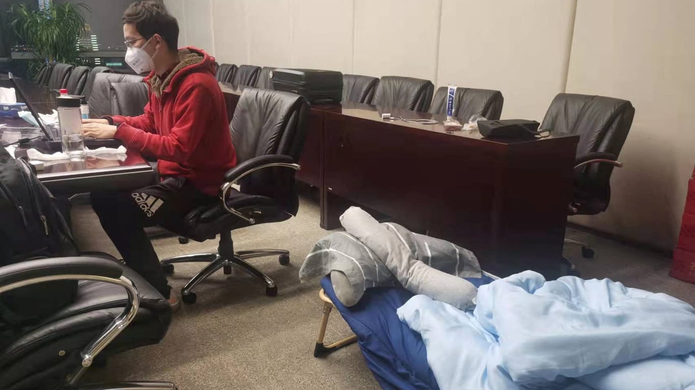 Ein Mitarbeiter der Bank of Communications hat sein Schlaflager in seinem Büro aufgestellt, um den Betrieb am Laufen zu halten.