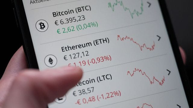 Eine Frau bedient die App "Bison", mit der Kryptowährungen gekauft und verkauft werden können. Eine Frau bedient die App "Bison", mit der Kryptowährungen gekauft und verkauft werden können.