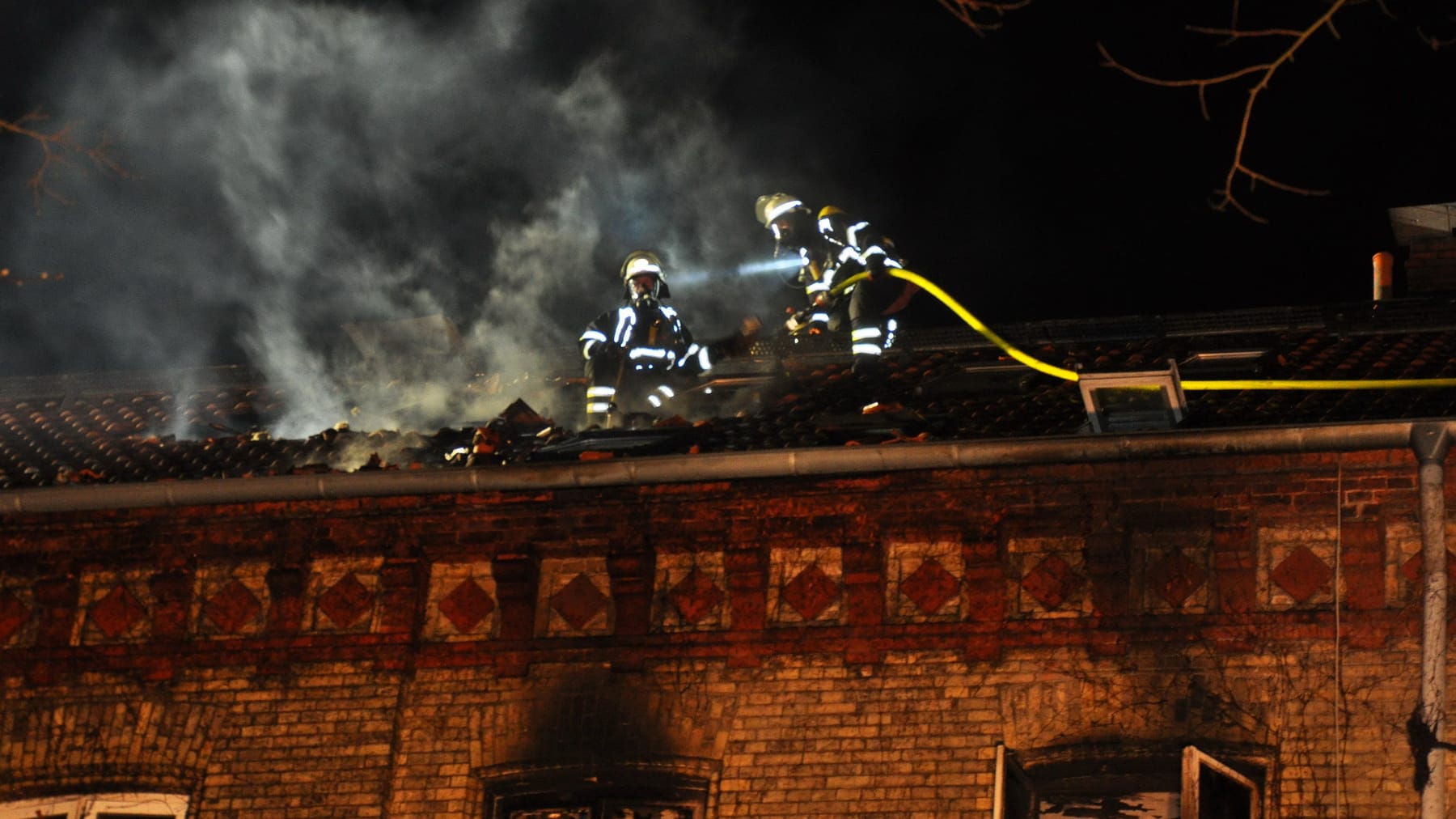 Feuerwehrleute auf dem zerstörten Dach: Mehrere Menschen konnten gerettet werden. Feuerwehrleute auf dem zerstörten Dach: Mehrere Menschen konnten gerettet werden.