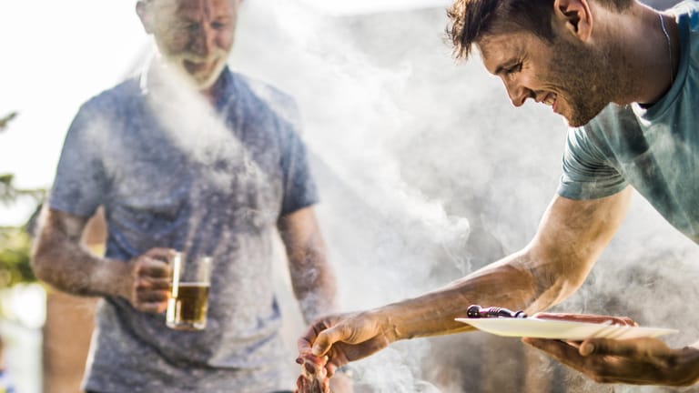 Männer am Grill (Symbolbild): Ungesunde Ernährung und Alkohol haben direkte Auswirkungen auf die Lebenserwartung.