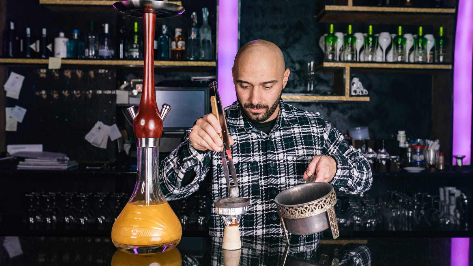 Ein Mann bereitet eine Wasserpfeife vor (Symbolbild): Shisha werde zum Großteil zu Hause und nicht in Shishabars geraucht, so der Shishaverband.