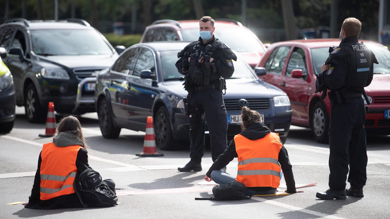 Demonstranten und Polizisten in Frankfurt: Die Aktivisten haben sich an die Straße geklebt.