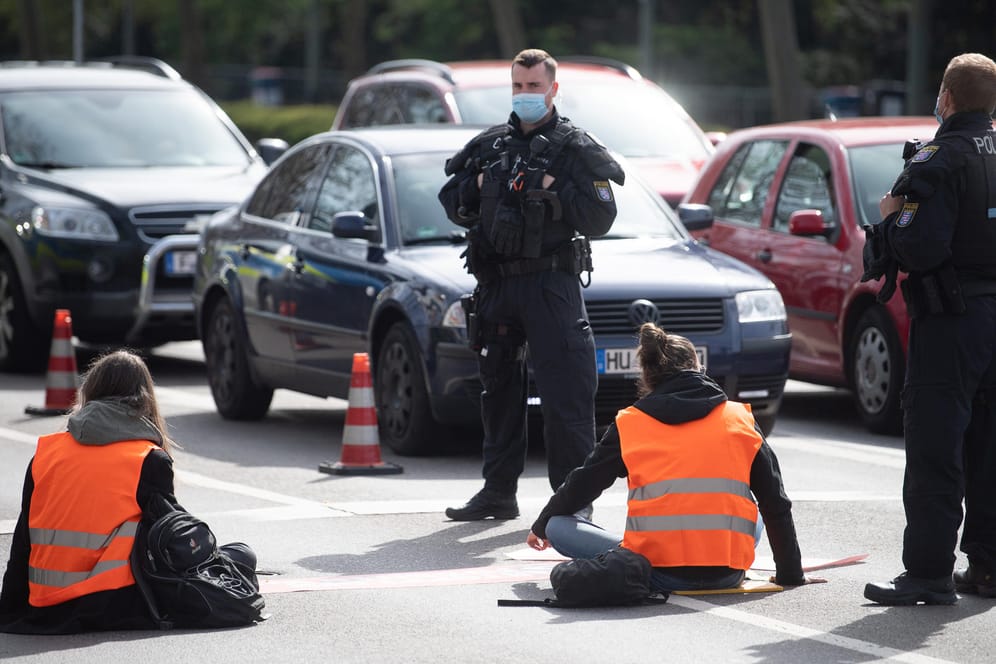 Demonstranten und Polizisten in Frankfurt: Die Aktivisten haben sich an die Straße geklebt.