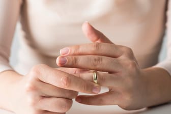 Frau mit Ehering (Symbolbild): Um den Ring schön zu halten, sollte man ihn bei einigen Alltagsaufgaben besser absetzen.