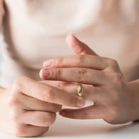 Frau mit Ehering (Symbolbild): Um den Ring schön zu halten, sollte man ihn bei einigen Alltagsaufgaben besser absetzen.