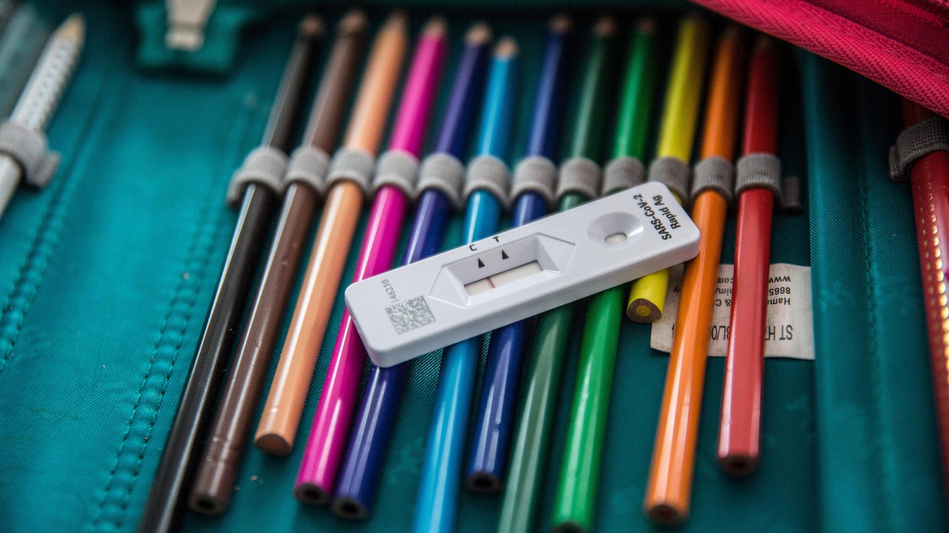 Federmäppchen mit einem negativen SARS-CoV-2 Test (Symbolbild): An den Schulen in Berlin werden immer weniger Kinder positiv getestet.