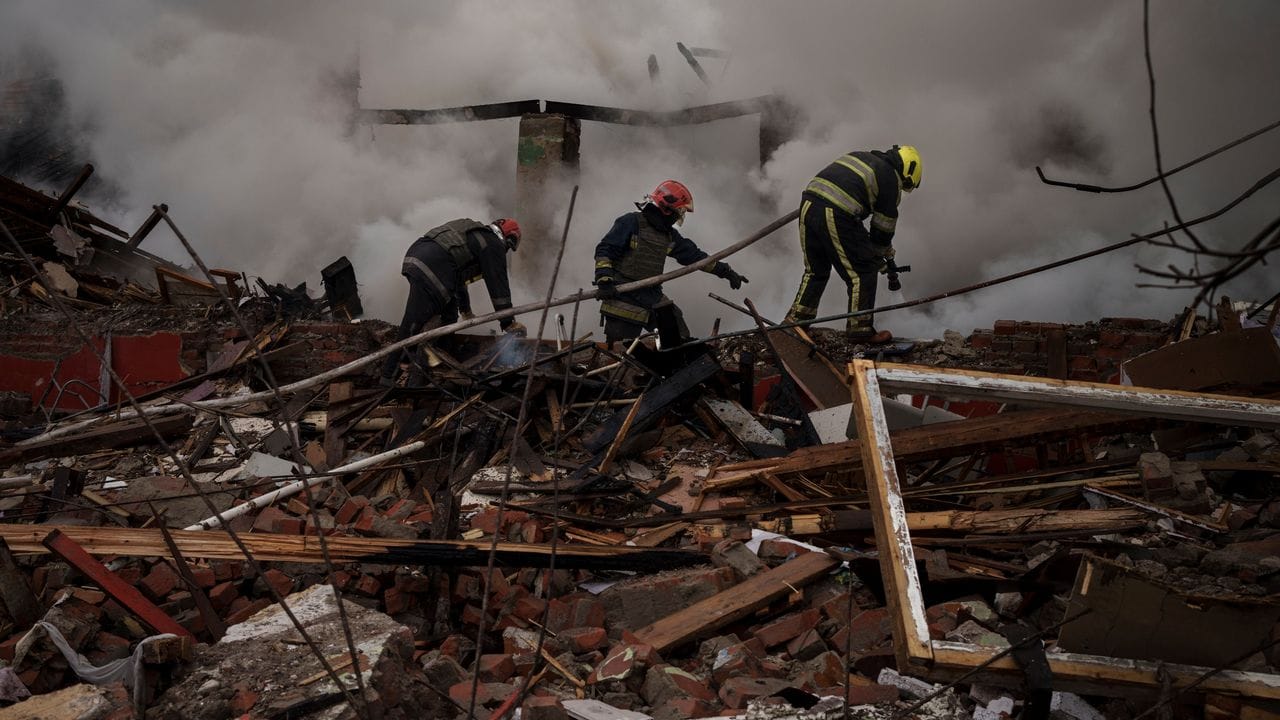 Feuerwehrleute arbeiten daran, ein Feuer nach einem russischen Angriff in Charkiw zu löschen.