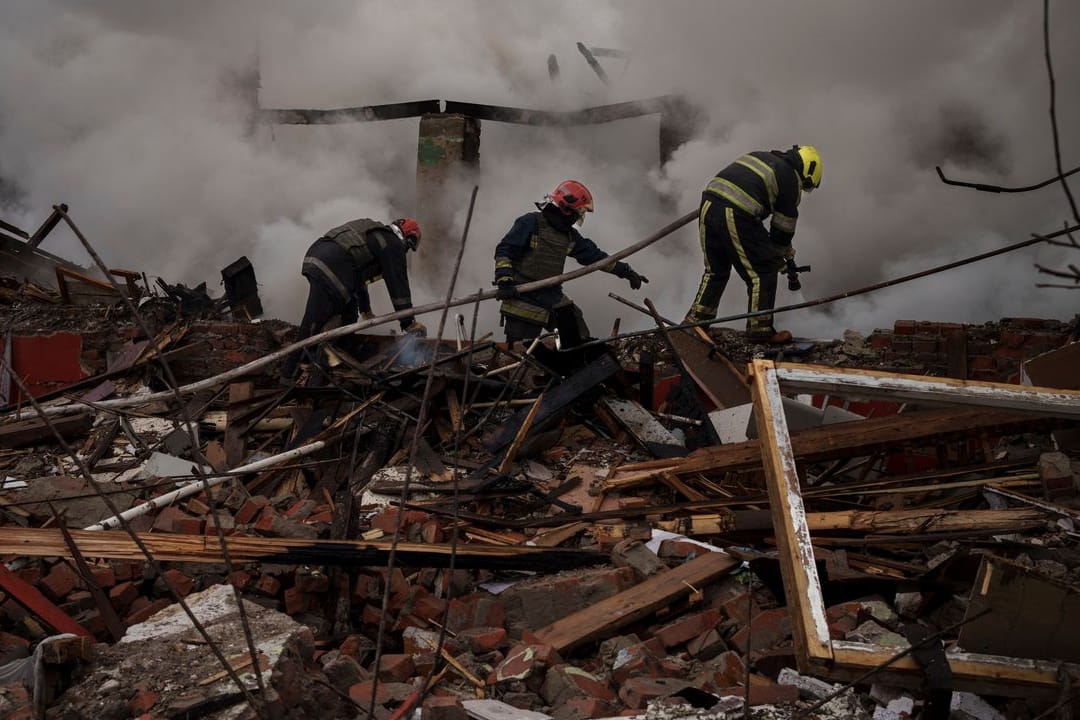 Feuerwehrleute arbeiten daran, ein Feuer nach einem russischen Angriff in Charkiw zu löschen.