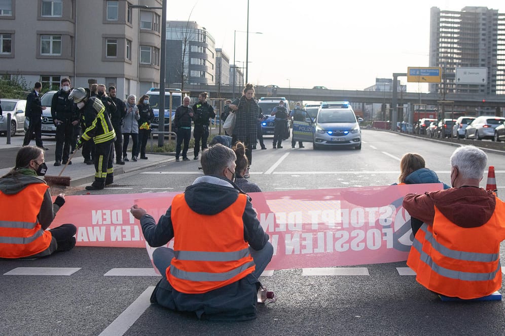 Aktivisten sitzen während eines Protests auf der Straße: Die "Letzte Generation" verteilte Fake-Öl über die Straße.