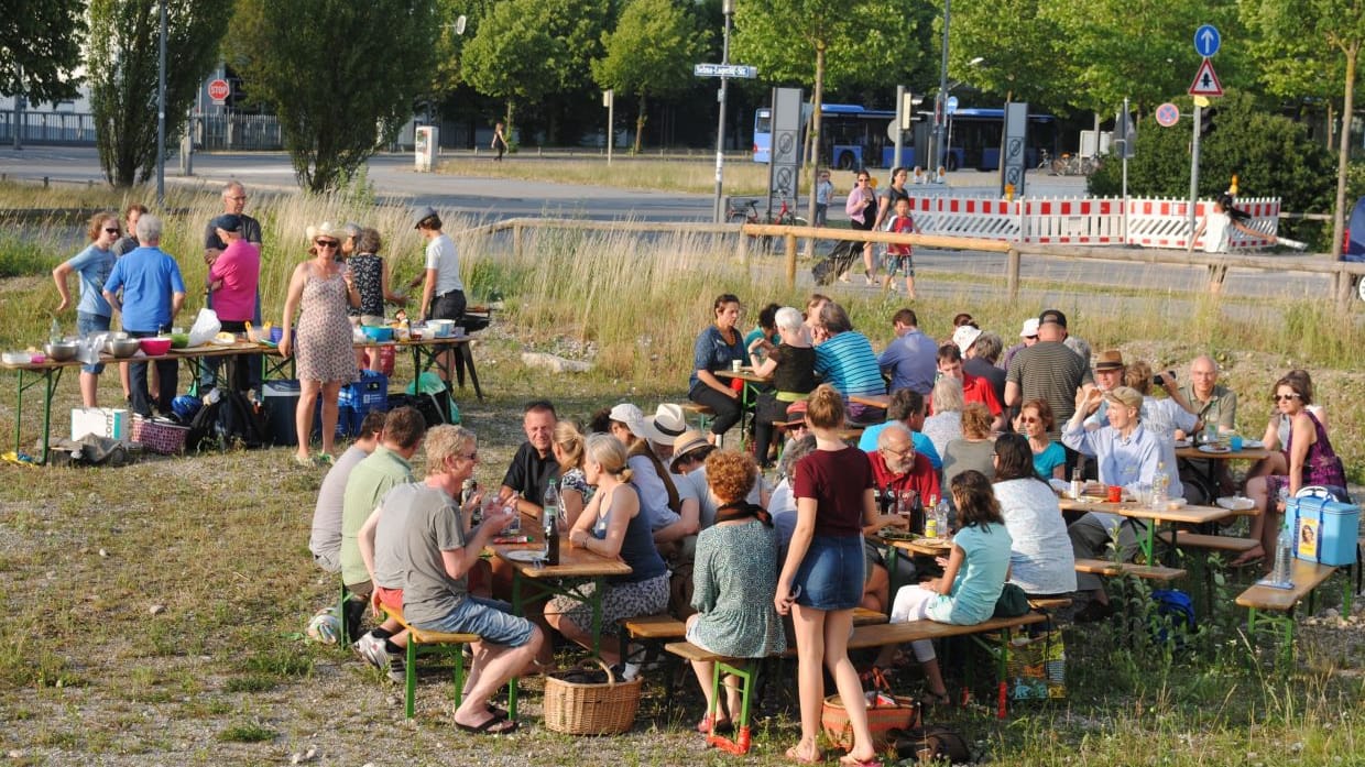 Die Nachbarn aus dem Wohnprojekt "Haus Rio" picknicken vor der Wohnanlage: Mehrere Generationen haben hier ein neues Zuhause gefunden. Ändern sich ihre Lebensumstände, lassen sich die Wohnungsgrößen anpassen.