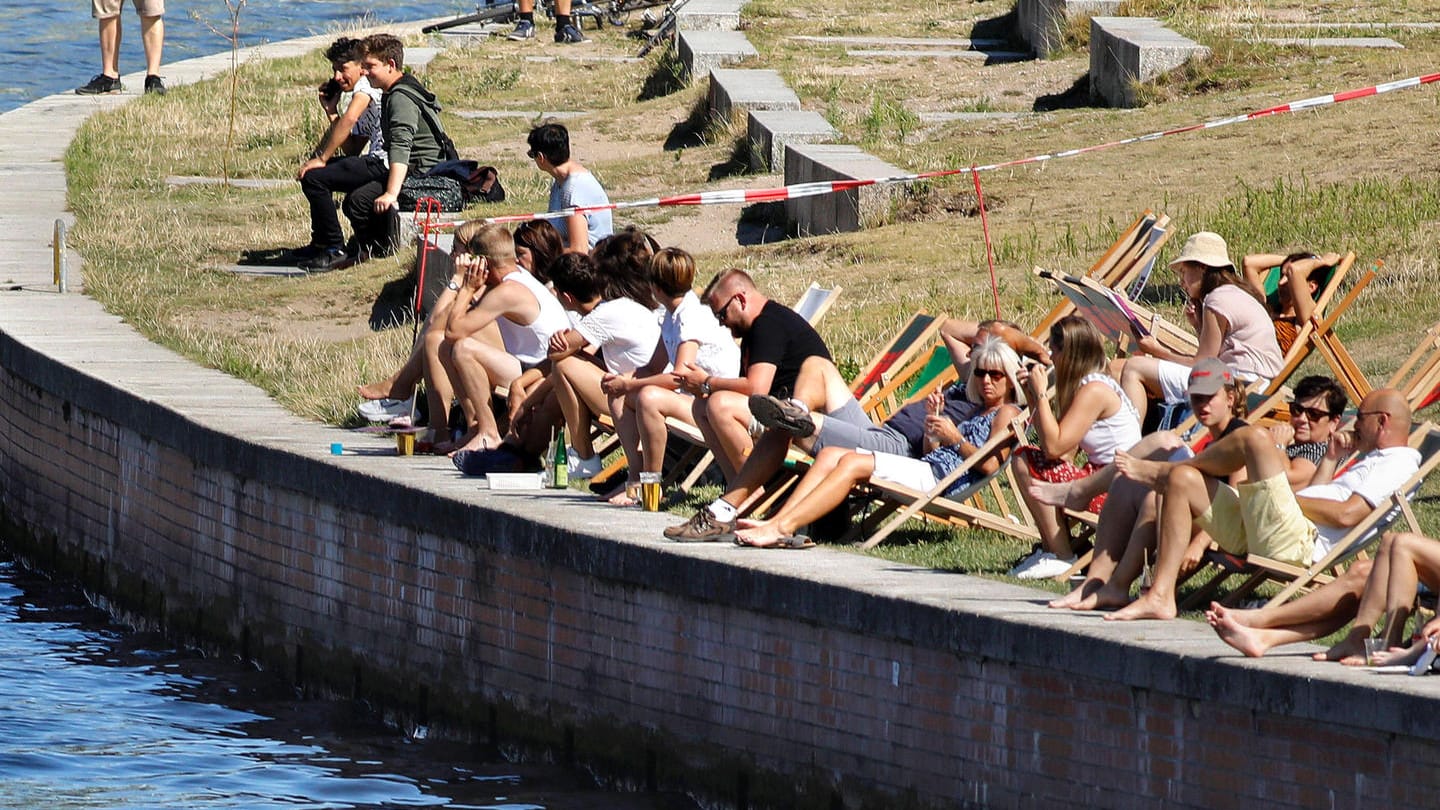 Menschen genießen am Spreeufer in Berlin die Sonne (Archivbild): Experten warnen in diesem Jahr vor einer möglichen Coronawelle im Sommer.