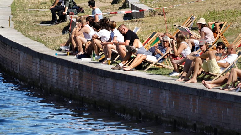 Menschen genießen am Spreeufer in Berlin die Sonne (Archivbild): Experten warnen in diesem Jahr vor einer möglichen Coronawelle im Sommer.