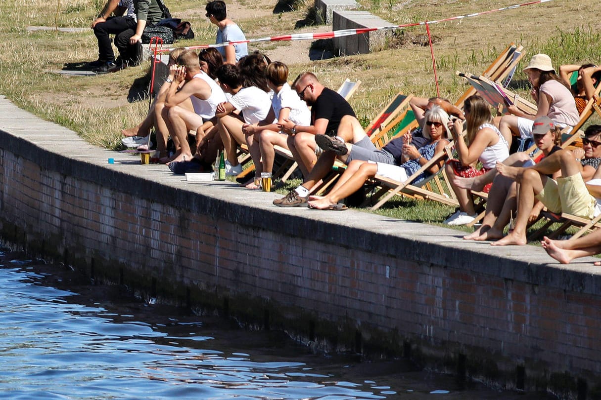 Menschen genießen am Spreeufer in Berlin die Sonne (Archivbild): Experten warnen in diesem Jahr vor einer möglichen Coronawelle im Sommer.